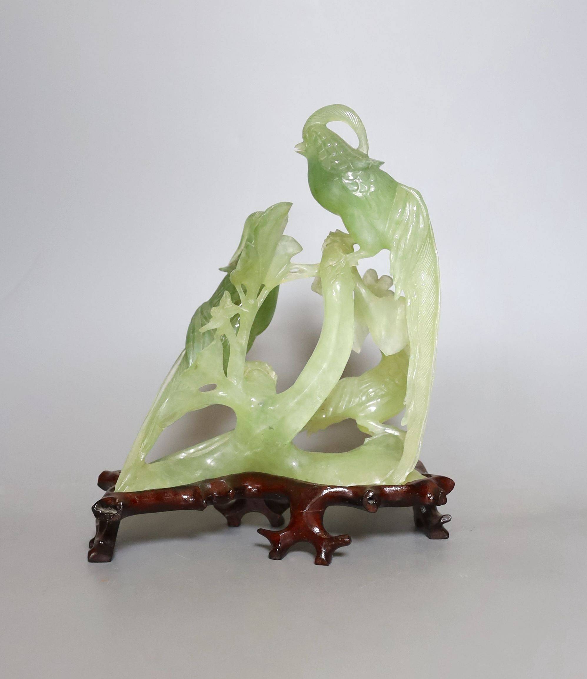 A Chinese bowenite jade bird group on wooden base - 23cm tall